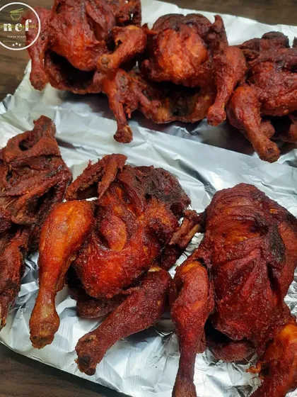 Whole fried chickens, fresh out of the pan and ready to be packed for an order. They are crispy, golden, and delicious.