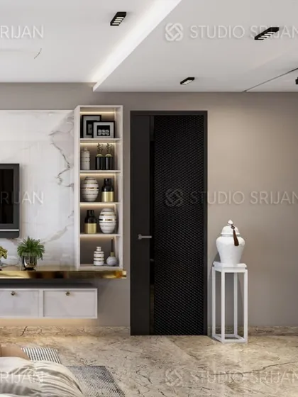 A detail shot of a bedroom in Rajouri Garden, showing a sleek, modern TV unit with a marble top and a dark, textured door.