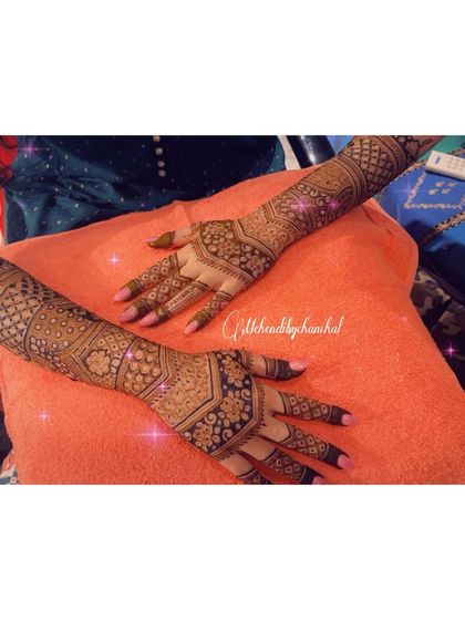 A full view of the engagement mehendi for Meenakshi, showing the intricate geometric patterns that cover the hands and arms.
