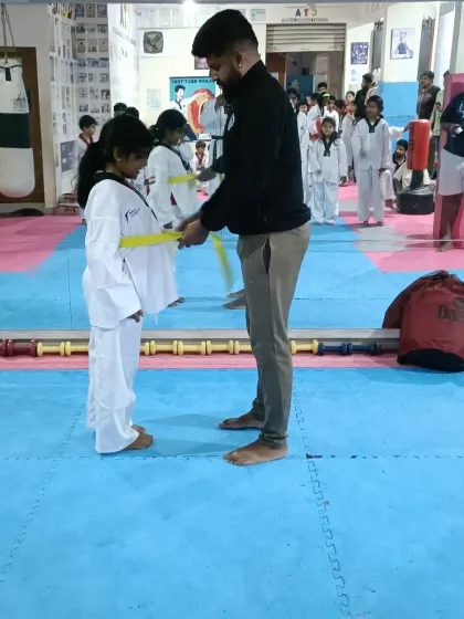 Tying a new yellow belt for a young student.