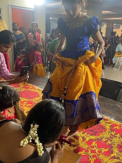 A behind-the-scenes moment from our Saraswati Pooja. Here, a student gets her 'alta' (red dye) applied to her feet, a traditional practice for dancers.