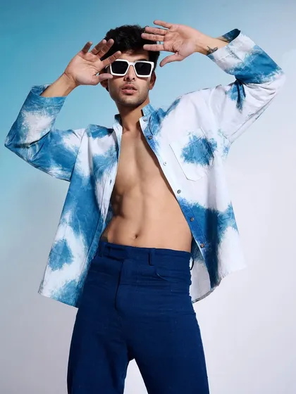 An expressive shot from the same indigo collection, with the model's open shirt revealing a confident pose. This style of photography helps sell a lifestyle, not just a piece of clothing.