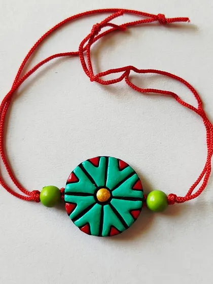 This rakhi has a bold geometric design in green and red. The clean lines and bright colors make it a modern and stylish choice for Rakshabandhan.