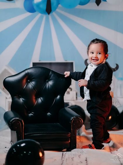 Sometimes the smallest things take the most room in your heart. A happy boss baby stands proudly by his chair.