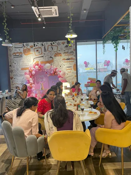 A view of our cafe during a party, where parents can sit back, chat, and enjoy a meal. The large windows and comfortable seating make it a bright and pleasant space for adults to relax.