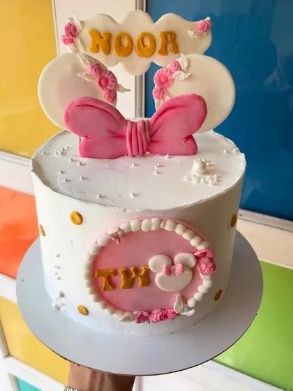 A chic and simple Minnie Mouse-themed cake with a big pink bow.