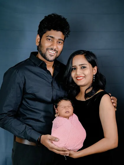 A beautiful portrait of a new family of three. The simple dark background keeps all the focus on their happy faces.