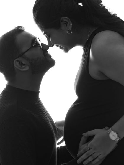 A moment of pure connection. This black and white silhouette captures the intimacy and excitement of the parents-to-be, their faces close together.