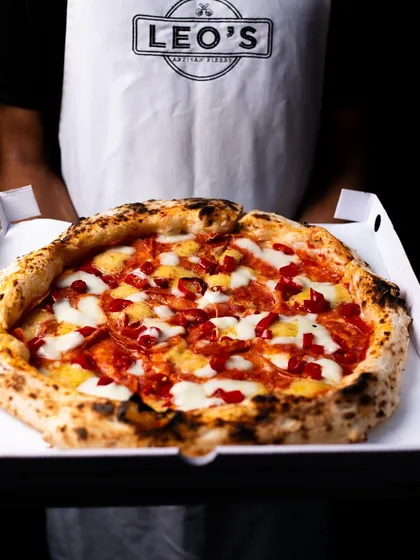 Serving pizza hot and fresh, straight from the oven to a takeout box.