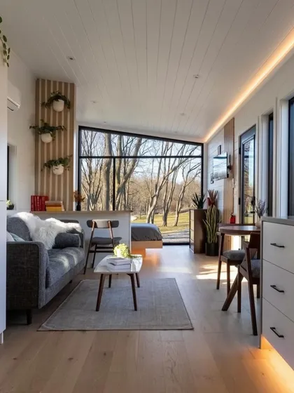 Step inside one of our modular holiday homes. This bright and airy living space, with its large windows and minimalist decor, shows that compact living doesn't mean compromising on style or comfort.