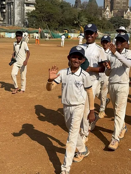 The walk of a winner. A young player from my U-14 team waves after a successful match at Azad Maidan, with his teammates applauding his performance.