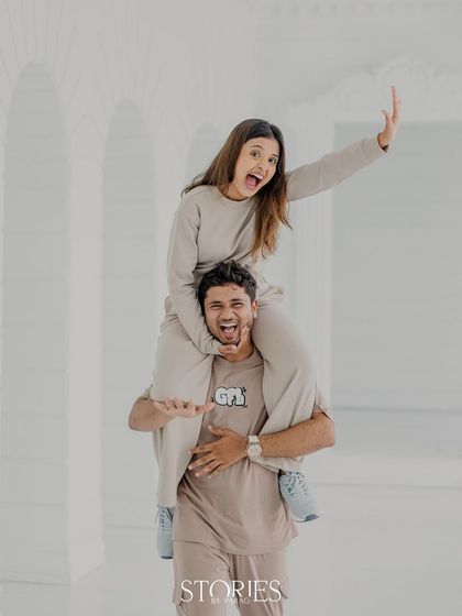 Twinning and winning! This playful shoulder-ride photo against a clean white backdrop is full of energy and laughter, showcasing the fun side of their relationship.