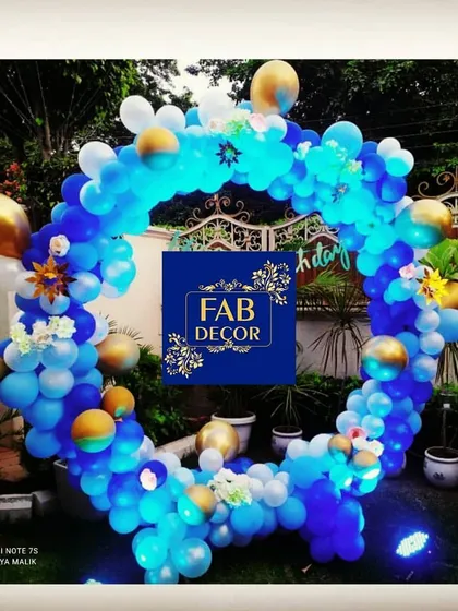 I also create decorations for outdoor events. This circular balloon arch, made with blue, white, and gold balloons, serves as a beautiful photo backdrop for birthdays or baby showers. I added small lights to make it stand out in the evening.