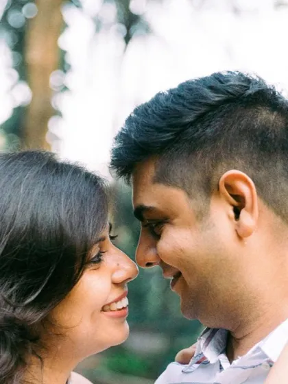 A tight close-up during an outdoor couple shoot highlights the genuine smiles and the light in their eyes. This image feels incredibly personal and captures the happiness they find in simply looking at each other.