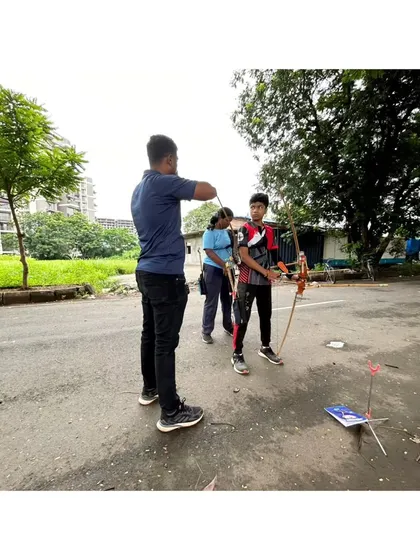 Hands-on coaching is key for beginners. I'm observing and correcting a young student's form as he practices with a traditional bow, ensuring he develops good habits right from the start.