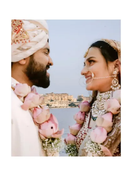A close-up of the couple with their lotus varmalas, the iconic City Palace visible across the lake, perfectly capturing the essence of their Udaipur wedding.