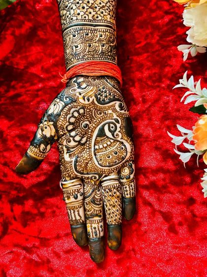 The other hand from the same bridal set, showcasing a large, heart-shaped paisley design. The fingers are adorned with various intricate patterns, completing the look.