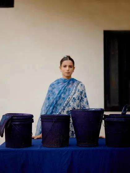 This shot highlights the indigo dyeing process, connecting the final product back to its artisanal roots for the Folksong Stories campaign.