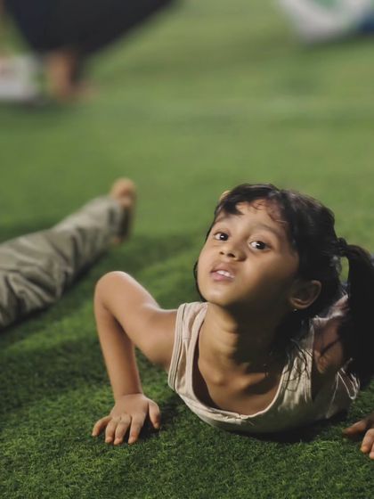 Determination in her eyes. A young girl pushes through a cobra pose, building strength in her arms and back.