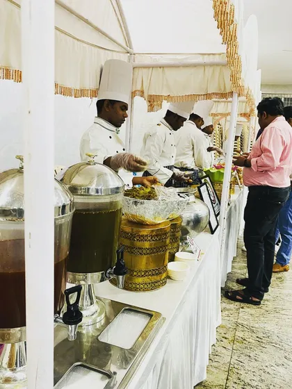A simple and efficient live counter setup for an indoor gathering. My chefs, in full uniform, are ready to serve fresh food to guests, ensuring quality service in any venue.