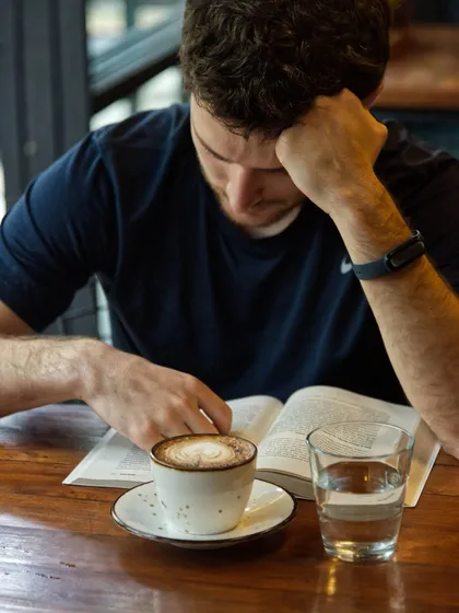 A quiet morning moment at Brik Oven. A customer enjoys a book and a coffee, making our space their own.