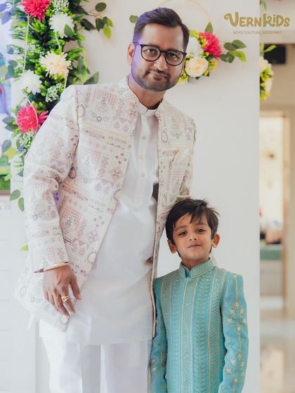 A beautiful father-son moment, with the little one shining in his custom blue sherwani. We love creating outfits that complement the entire family's style for special occasions.