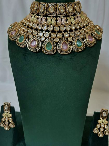 A multi-coloured choker necklace with pink and green stones. This rental piece can be paired with a variety of traditional outfits.
