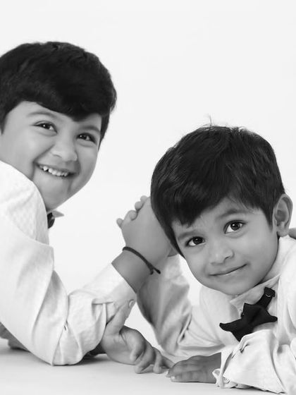 A classic black and white portrait of two brothers, capturing a moment of connection and affection between them.