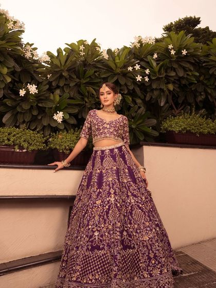 A full-length shot of the Noor lehenga against a beautiful floral backdrop.