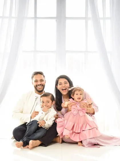 A bright and cheerful family photo filled with laughter. This candid moment against a high-key window backdrop perfectly captures the joy of family life.