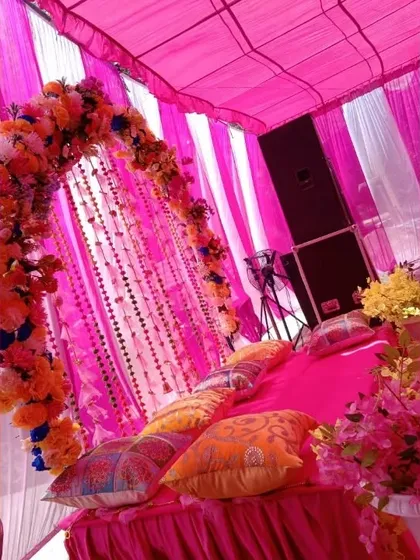 A side view of the pink-themed low seating arrangement, showing the colorful cushions for guests. This is a great setup for applying mehndi comfortably.