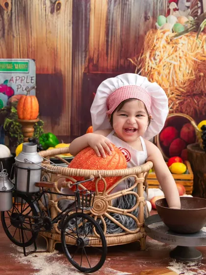 Having fun at the market. The bicycle prop adds another layer of playfulness to this already charming little chef theme.