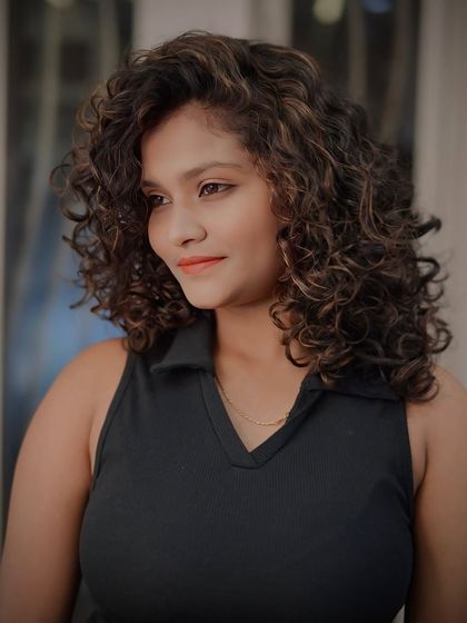 A portrait of our client with her beautifully colored and defined curls, styled using a diffuser to enhance the natural pattern.