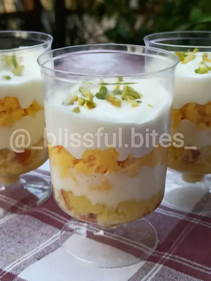 A close-up of three Rasmalai Fusion dessert cups, showing the creamy layers and pistachio garnish. A truly indulgent sweet treat.
