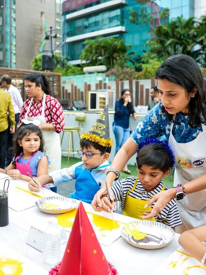 An instructor guiding the little artists at their painting station. I ensure there is proper guidance for all creative activities.