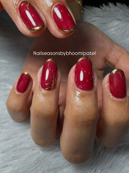 The gold chrome detail adds a touch of luxury to this classic red manicure.