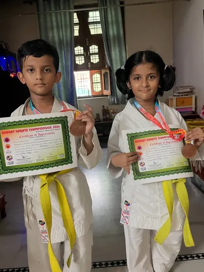 The winning feeling doesn't end at the competition. Two of our students proudly displaying their medals and certificates of appreciation at home.