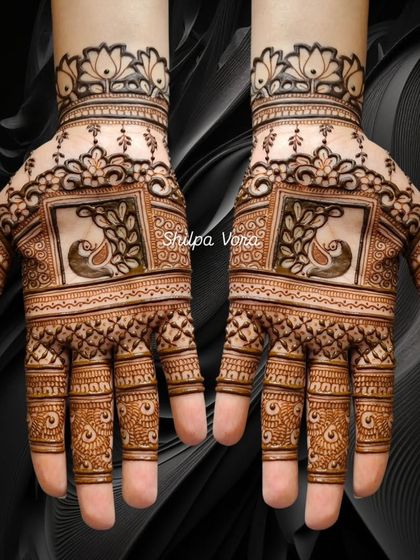 This symmetrical design features peacocks within square frames, a modern take on traditional Karwa Chauth mehndi.