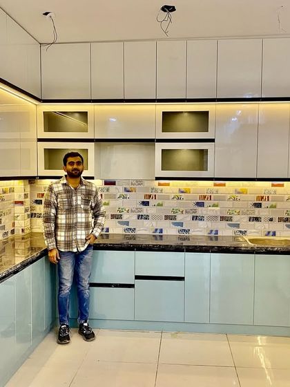 Standing in a newly finished dual-tone kitchen. The combination of light blue and white gives the space a calm and airy feel.