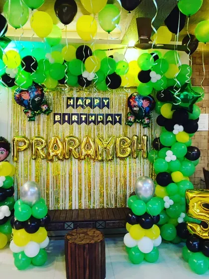 A Ben 10 themed fifth birthday party, perfect for action-loving kids. The decoration is built around the character's signature green, black, and white colors, with a shimmer backdrop and Ben 10 foil balloons.