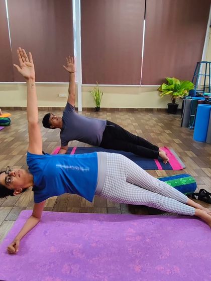 Students practice a side elbow plank in class. This variation is excellent for strengthening the oblique muscles, reducing side fat, and building shoulder stability.