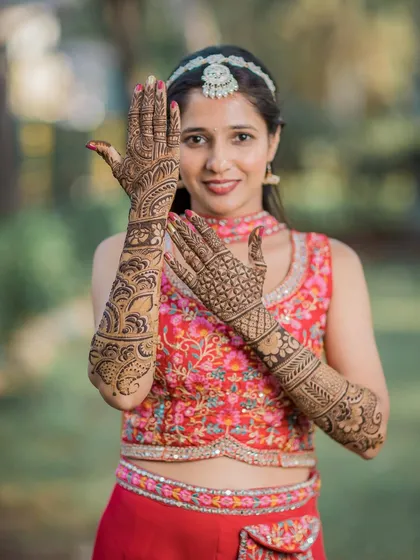 A clear and detailed shot of the bride's full bridal henna, showcasing the intricate patterns on her hands and arms.