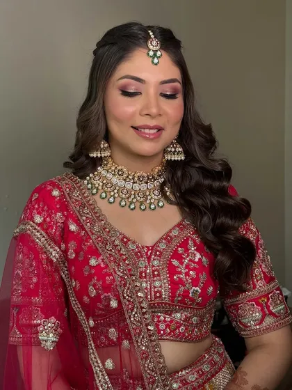 Another angle of this stunning red bridal look, showing how the makeup looks flawless even with eyes closed. The shimmer on the lids catches the light beautifully.
