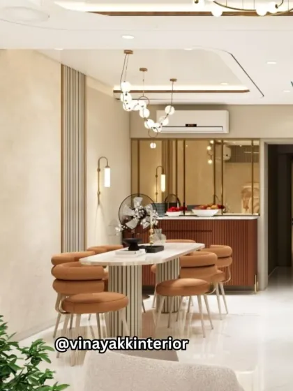 An open-concept design connecting the dining and kitchen areas. The warm, earthy tones of the dining chairs and kitchen bar create a cohesive flow, while modern pendant lights define each space.