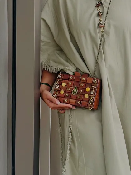 Here is a close up of my handcrafted wooden box clutch. I focused on the intricate details, from the polished wood blocks to the delicate embellishments, to create a piece that feels both rustic and luxurious. It's a unique accessory for a modern, earthy style.