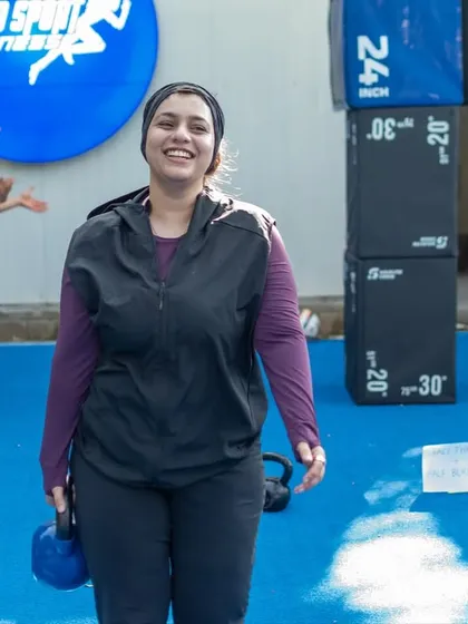 Our Saturday Surge event is all about moving, connecting, and starting the weekend right. Here, a member of our community smiles after a fun and challenging outdoor HIIT circuit. Fitness is about community as much as it is about exercise.