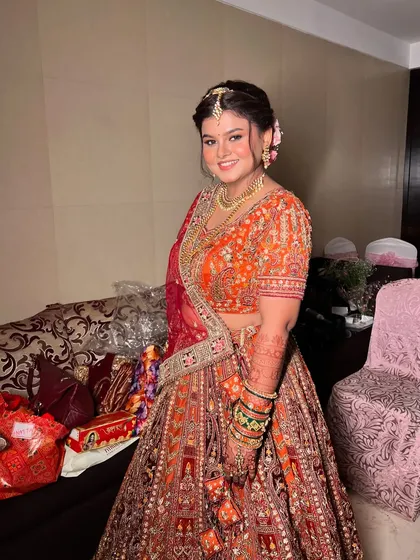 A full-length shot of Ankita, showing her stunning orange and red lehenga without the dupatta.