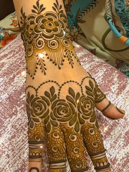 A lovely and delicate design on the back of the hand. The combination of rose motifs on the fingers and a hanging floral pattern at the wrist is very elegant.