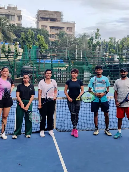 A group of our players posing by the net. We foster a welcoming environment for everyone, from those just starting to seasoned players.