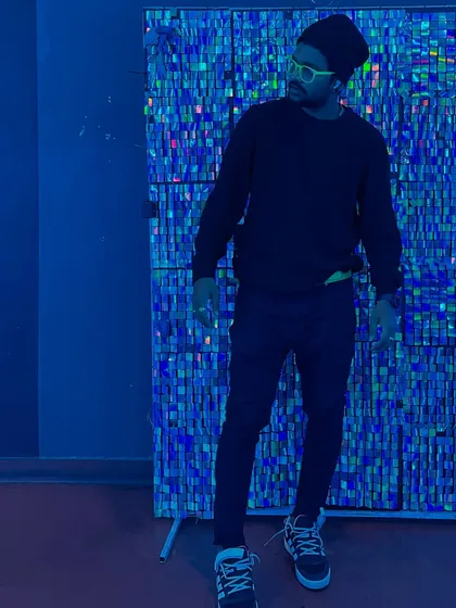 Posing against a shimmering blue backdrop, reflecting the cool, electronic side of my sound.